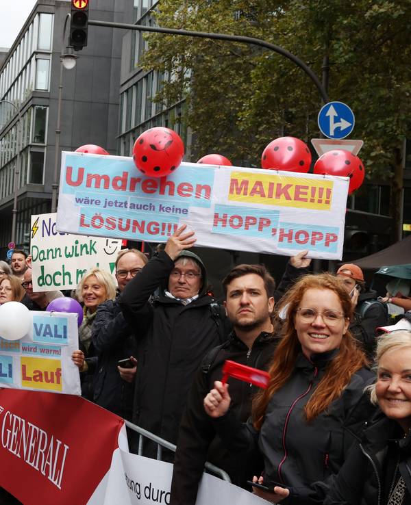 Zuschauer halten am Streckenrand des Köln-Marathons Schilder hoch, auf denen sie Maike und Vali anfeuern. „Umdrehen wäre jetzt auch keine Lösung“ steht auf einem Schild.