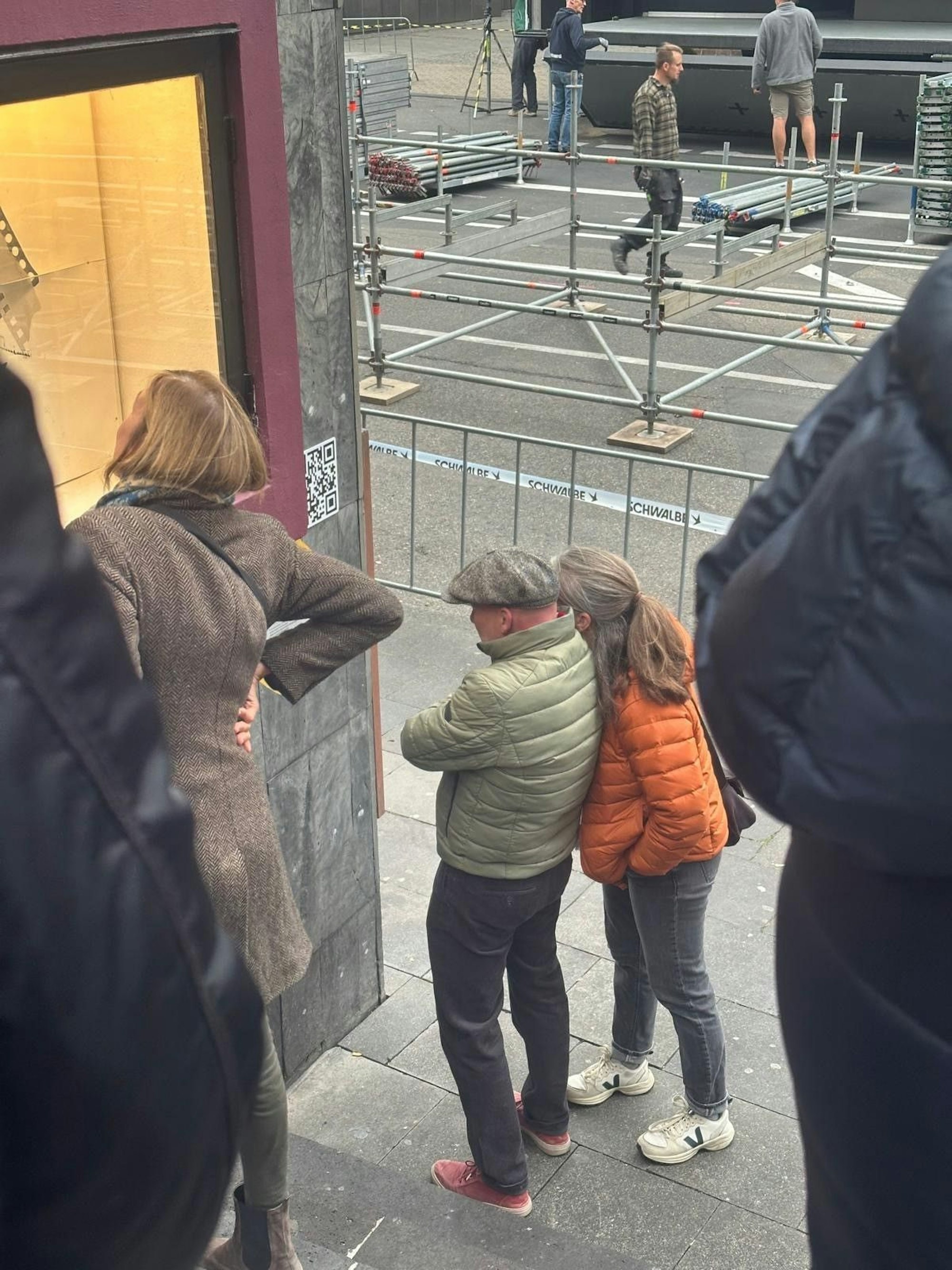 Menschen betrachten Schaukästen an einer Wand.