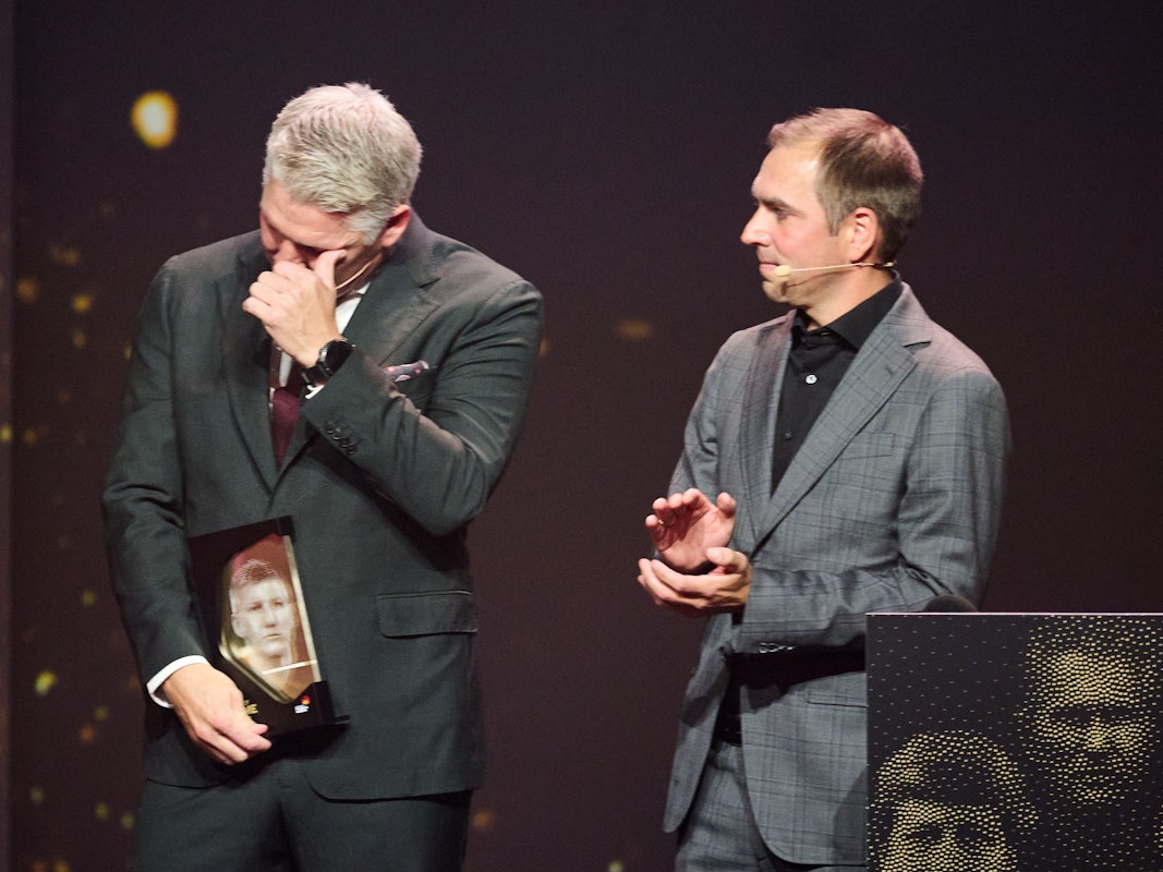 Bastian Schweinsteiger, neu ernanntes Mitglied der Hall of Fame des deutschen Fußballs, reagiert emotional neben Laudator Philipp Lahm auf der Bühne.
