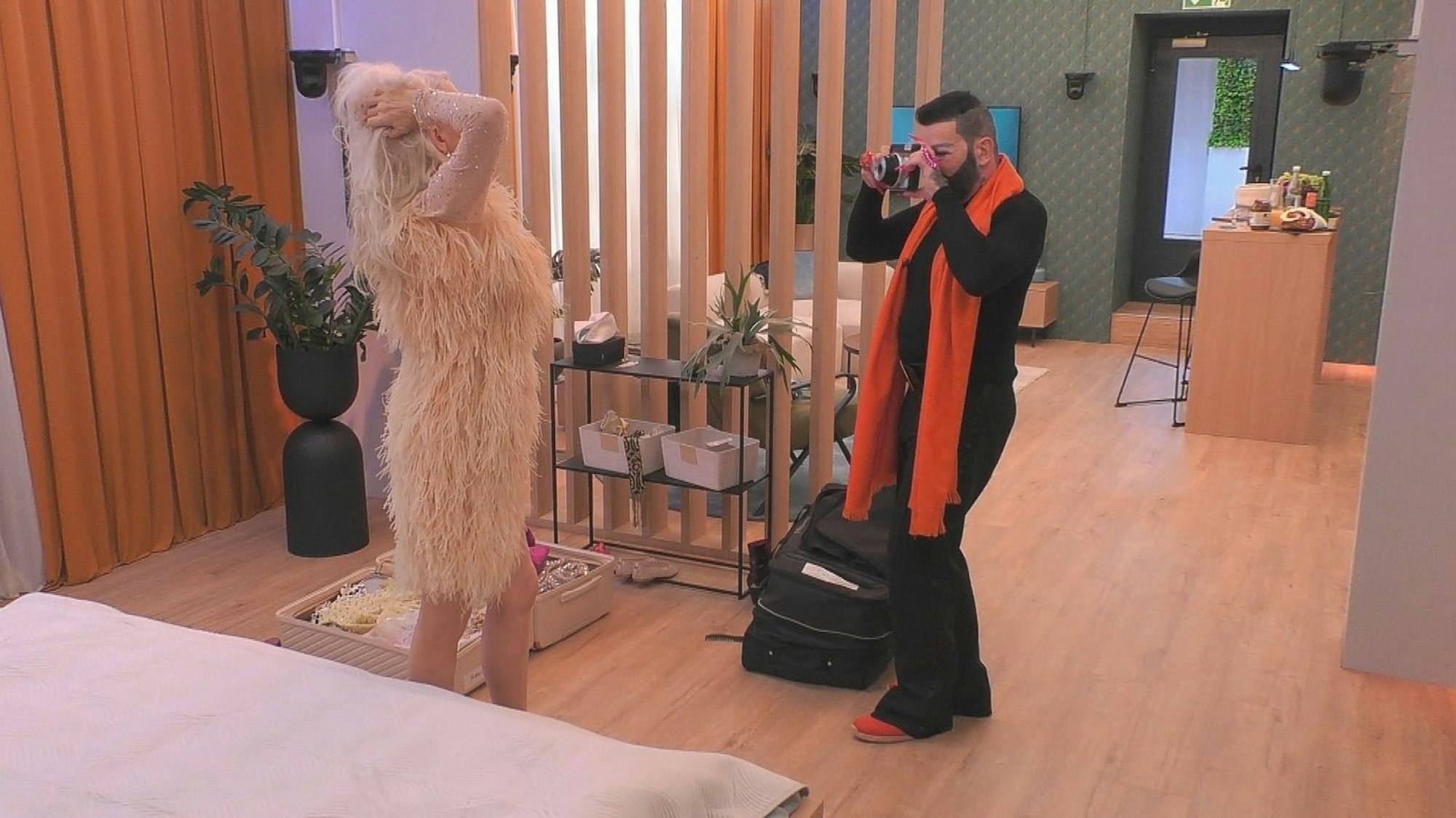 Die Zeit in der Musterwohnung vertrieben sich die beiden Reality-Stars mit Champagner, küssen und einem Fotoshooting. (Bild: Joyn)