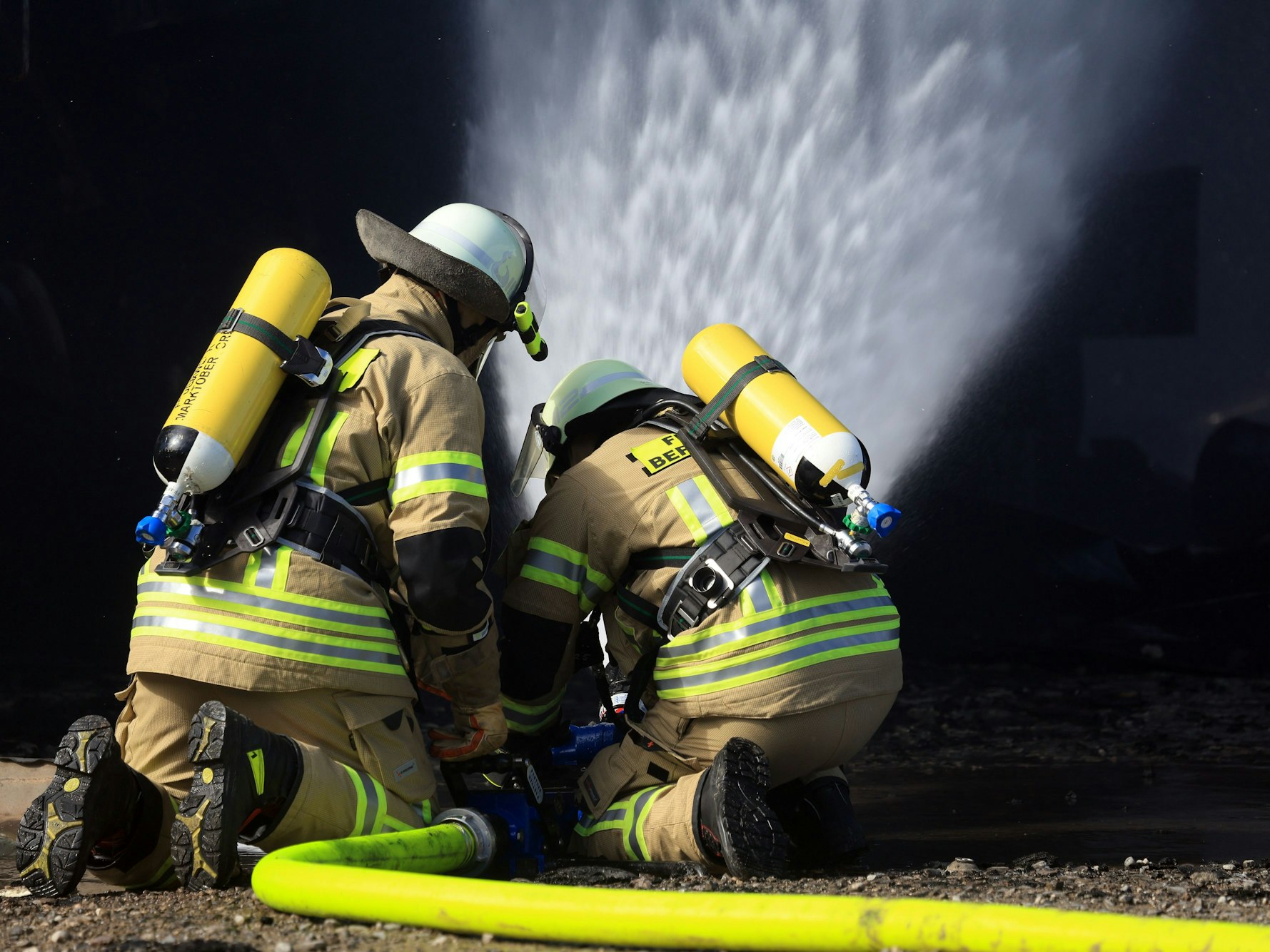 In Mülheim kam es zu einem Brand in einem Parkhaus. Das Symbolfoto zeigt Feuerwehrleute mit Atemschutzgerät beim Löschen in einer ausgebrannten Maschinenhalle.