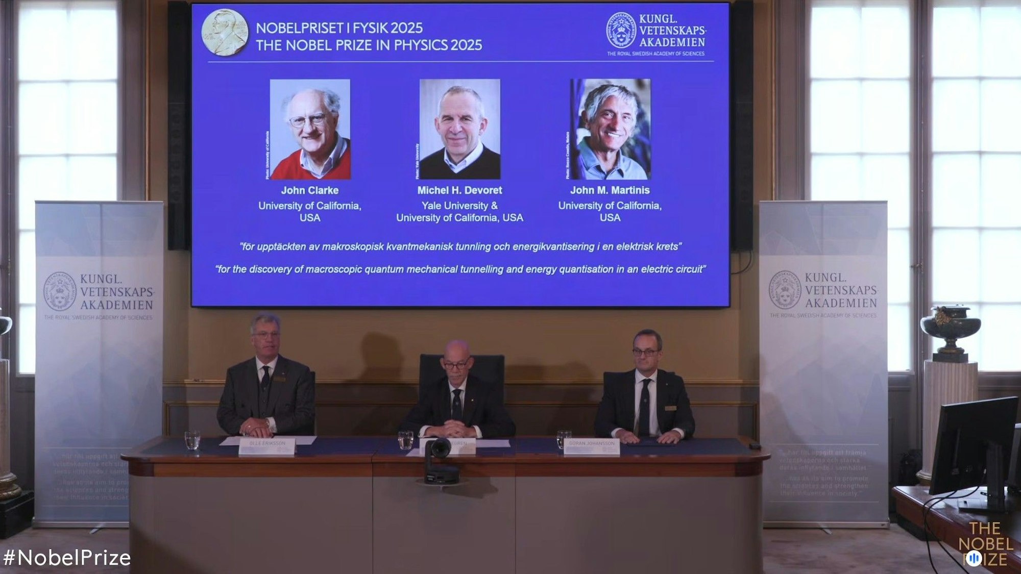 Auf einer Leinwand ist die Präsentation der diesjährigen Preisträger, die in den USA forschenden Quantenphysiker John Clarke (l-r), Michel Devoret und John Martinis, zu sehen.