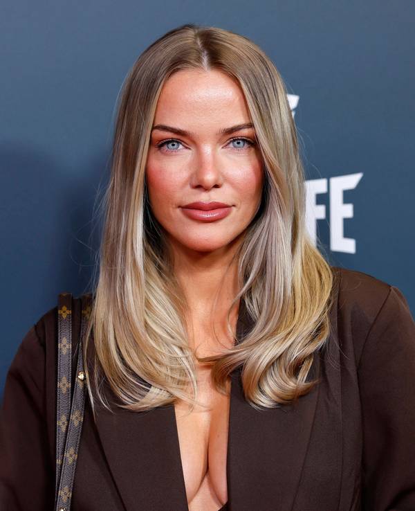 Laura Maria Rypa mit blonden Haaren, blauen Augen vor blauem Hintergrund und „FE“-Logo