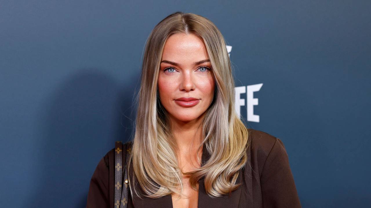 Laura Maria Rypa mit blonden Haaren, blauen Augen vor blauem Hintergrund und „FE“-Logo