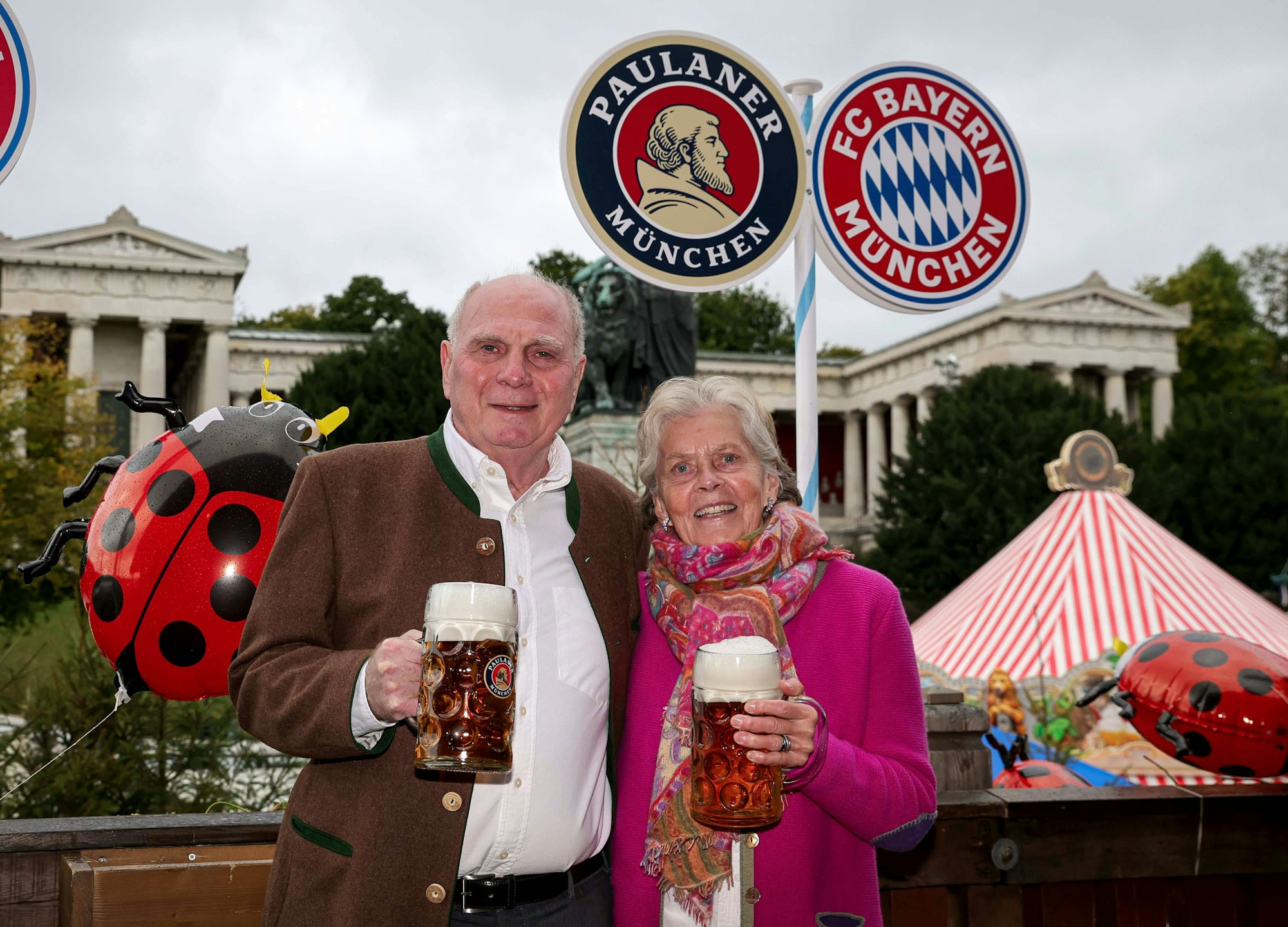 Uli Hoeneß und Sissy Hoeneß mit Bierkrügen vor Paulaner und Bayern Logos