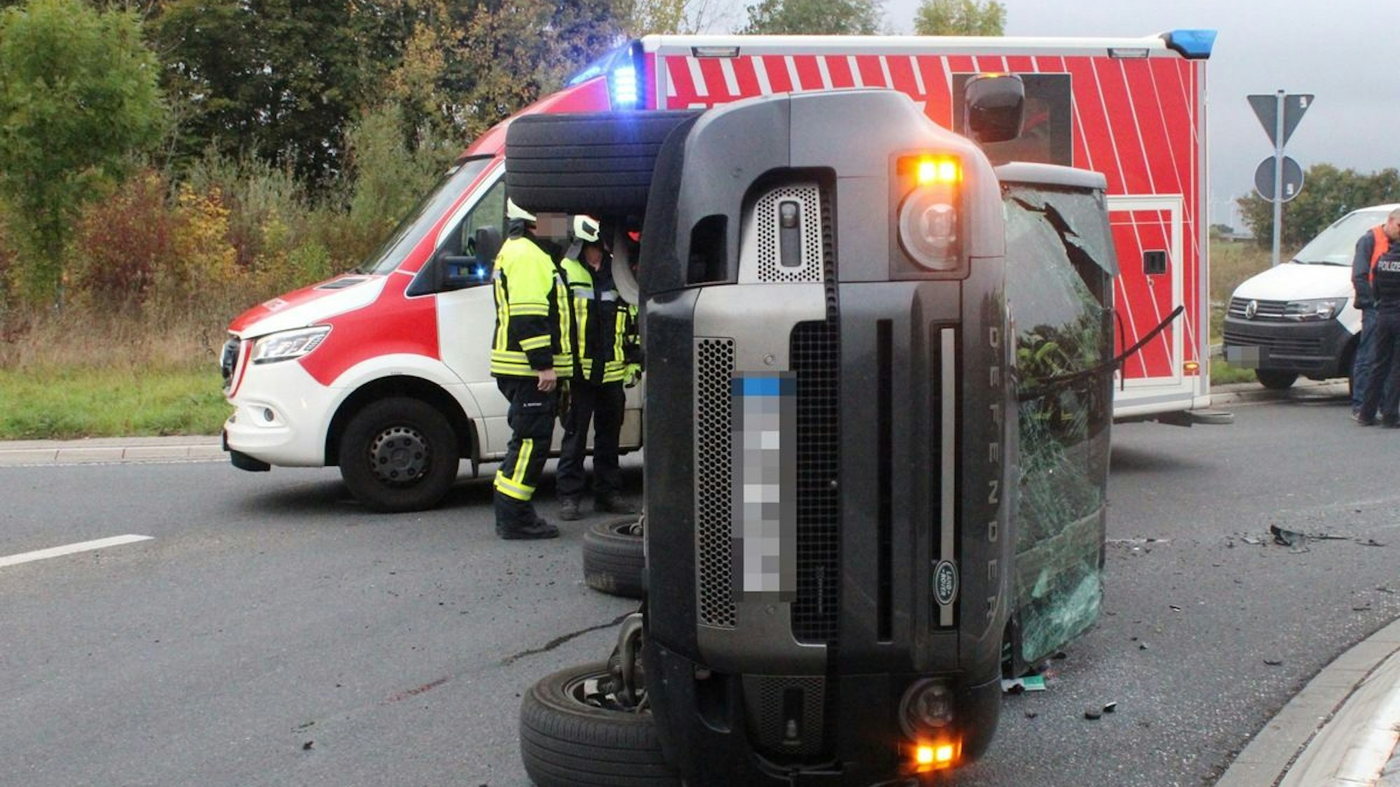 Ein auf die Seite gekipptes Auto in einem Kreisverkehr nach einem Unfall.