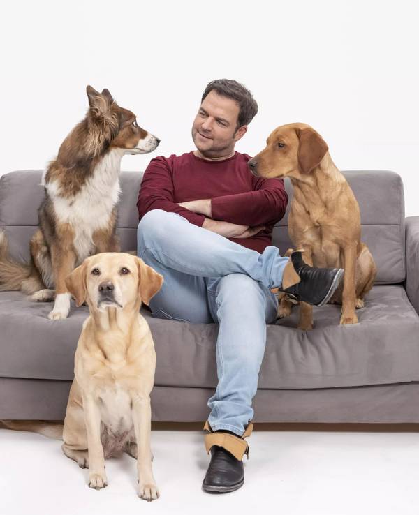 Martin Rütter mit Hunden auf einem Sofa