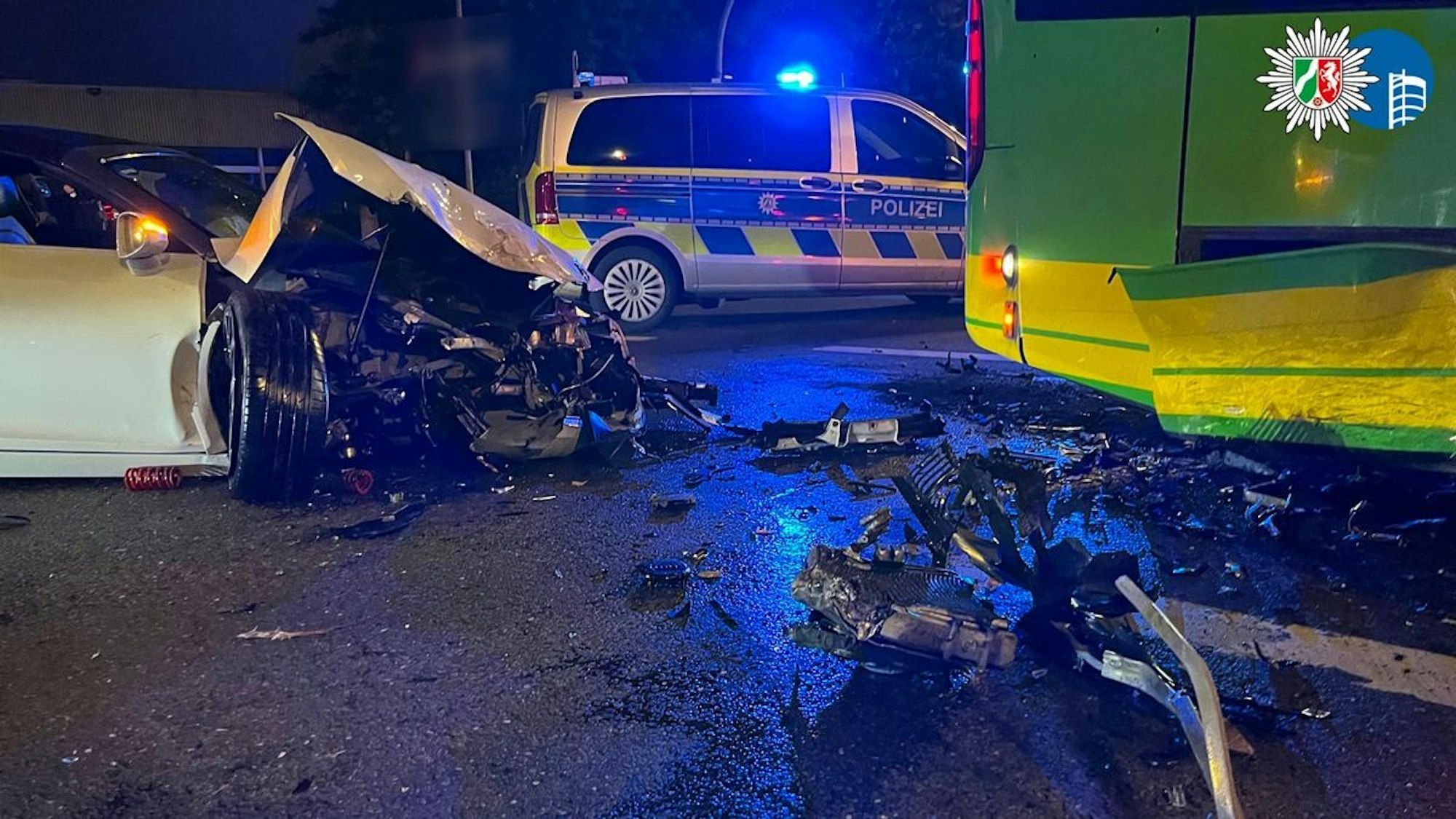 Ein weißer, an der Front zerstörter Audi R8 steht auf der Straße.