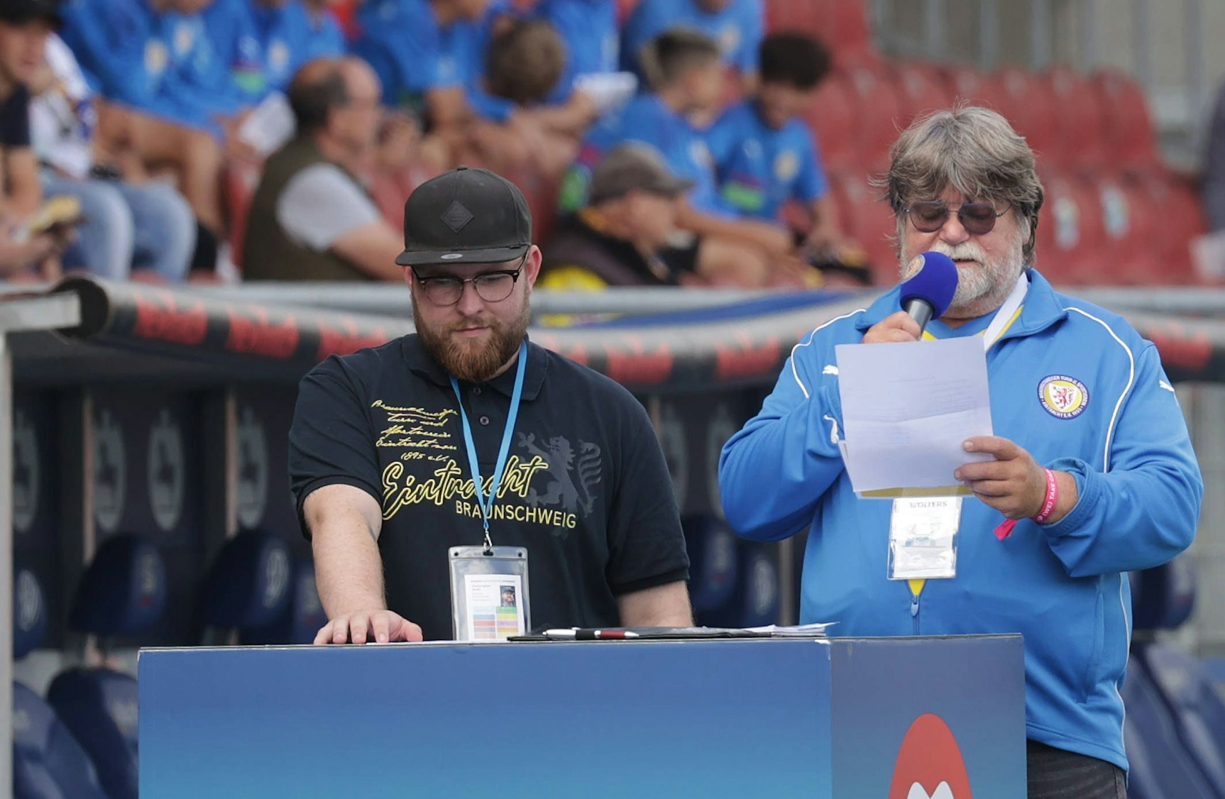 Zwei Männer moderieren bei einem „Eintracht Braunschweig“ Sportevent im Stadion