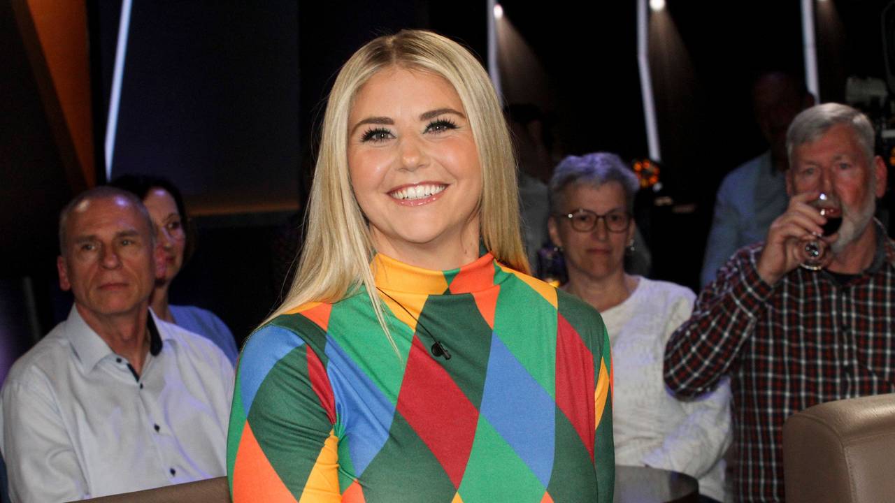 Beatrice Egli lächelt in buntem Oberteil vor Zuschauern