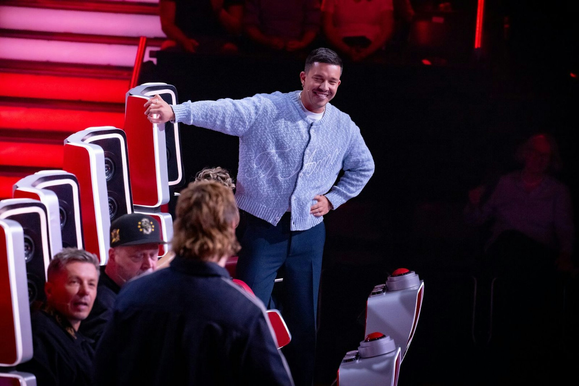 Es hält ihn meist nicht lange auf dem Sessel: Nico Santos muss immer wieder zeigen, welches vielfach begabte Musiktalent in ihm steckt. (Bild: Joyn/ Claudius Pflug)