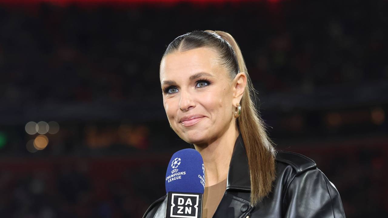 Laura Wontorra lächelt und hält ein DAZN Champions League Mikrofon
