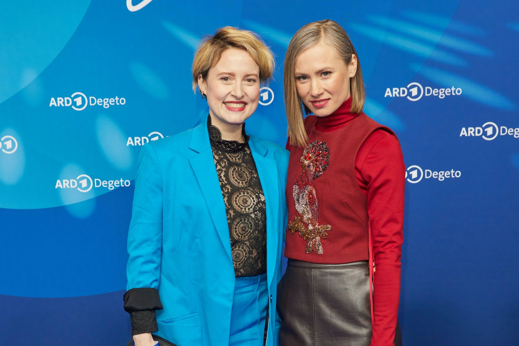 Wanda Perdelwitz und Alice Dwyer lächeln vor blauem ARD Degeto Hintergrund