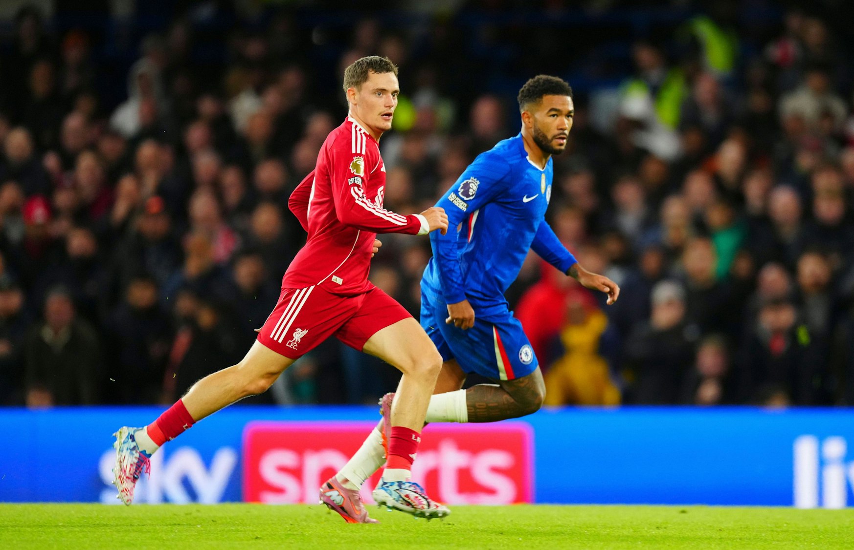 Symbolbild: Fußballspieler Joe Gomez (rot) und Reece James (blau) in Aktion auf dem Feld