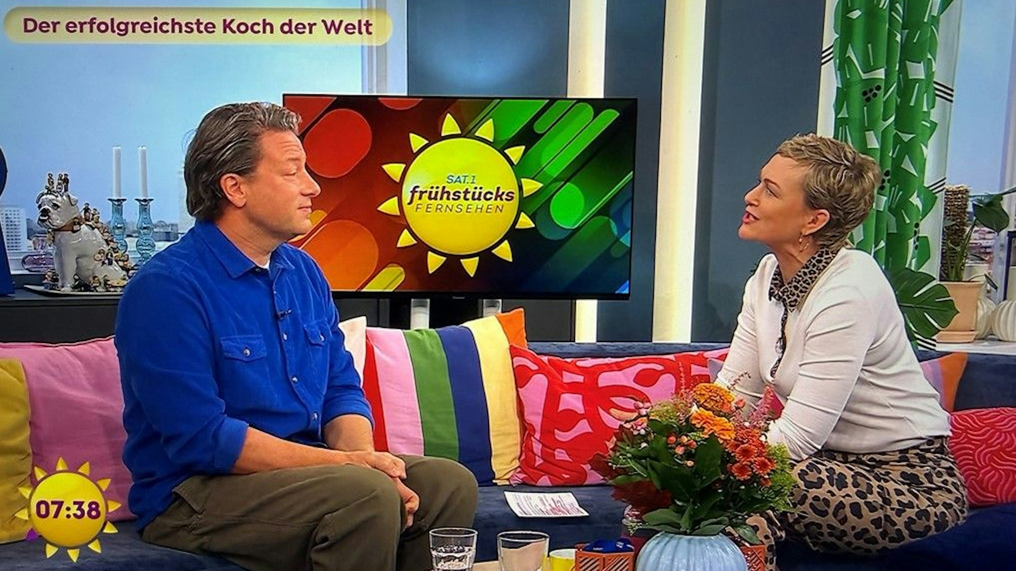 „Jamie Oliver“ Leuchtschild über hängenden grünen Lampen im Innenbereich