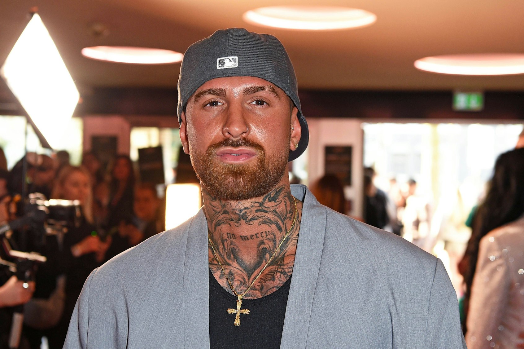 Gigi Birofio mit Bart, Tattoos und Baseballkappe auf einer Veranstaltung