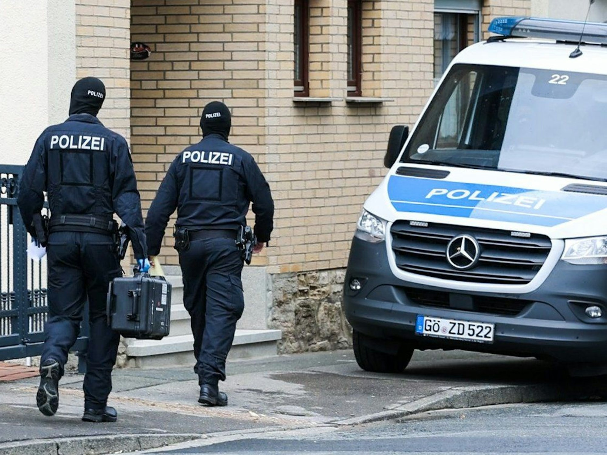 Polizisten sind bei einem Einsatz im Rahmen einer Razzia zu sehen.