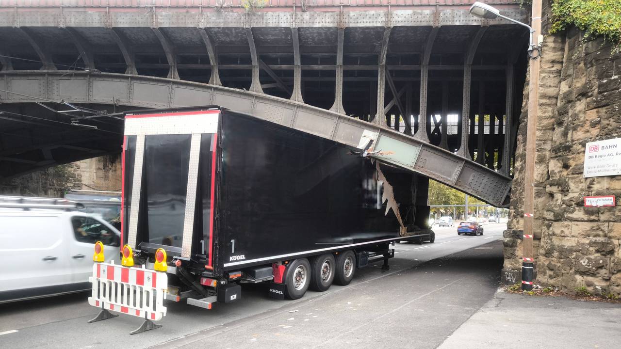 Ein Lkw klemmt unter einer Brücke, sein Auflieger ist eingedrückt.