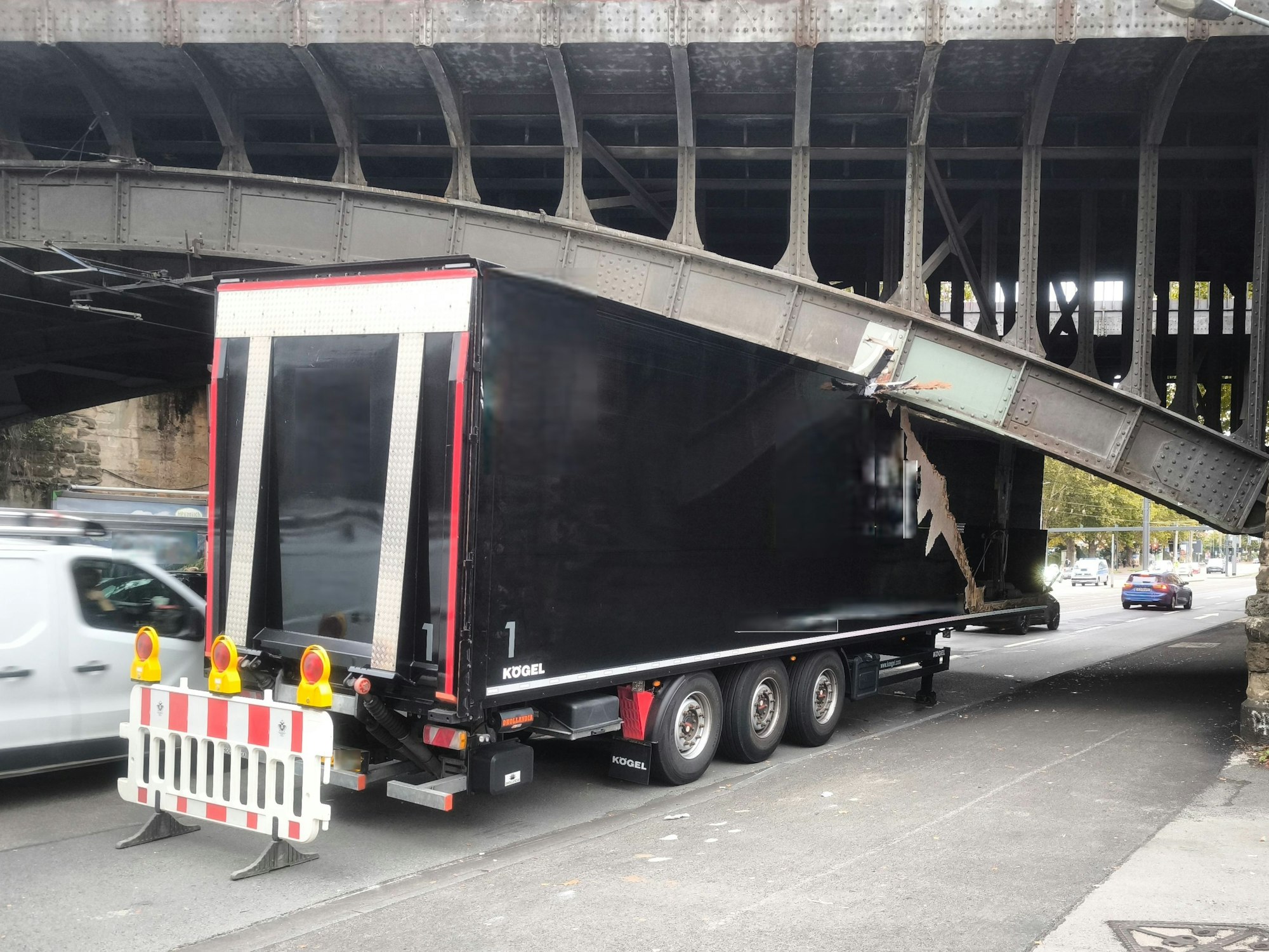 Ein Lkw klemmt unter einer Brücke, sein Auflieger ist eingedrückt.
