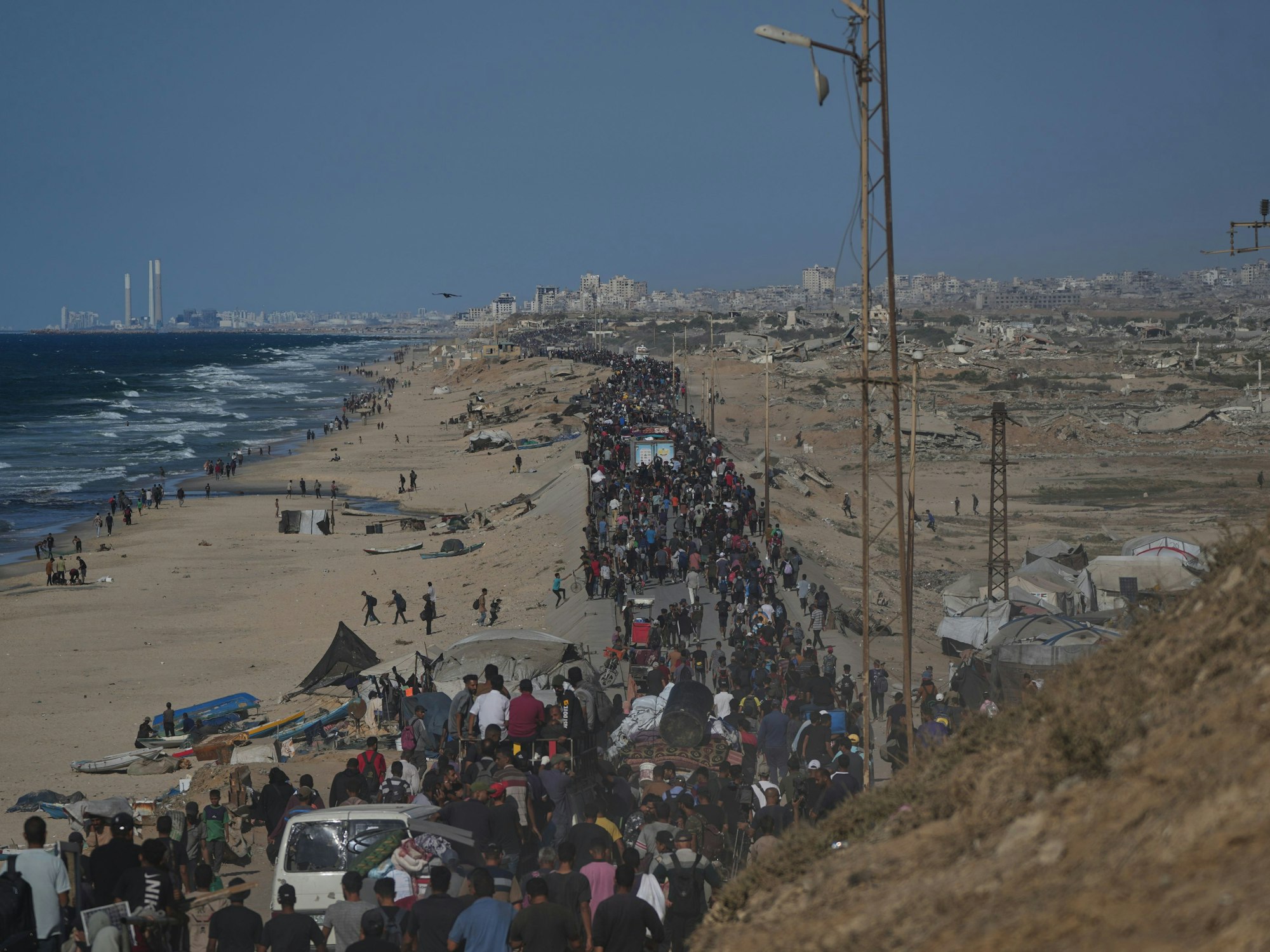Vertriebene Palästinenserinnen und Palästinenser gehen mit ihren Habseligkeiten auf der Küstenstraße in der Nähe von Wadi Gaza im zentralen Gazastreifen in Richtung Gaza, nachdem Israel und die Hamas eine Pause in ihrem Krieg und die Freilassung der restlichen Geiseln vereinbart haben.