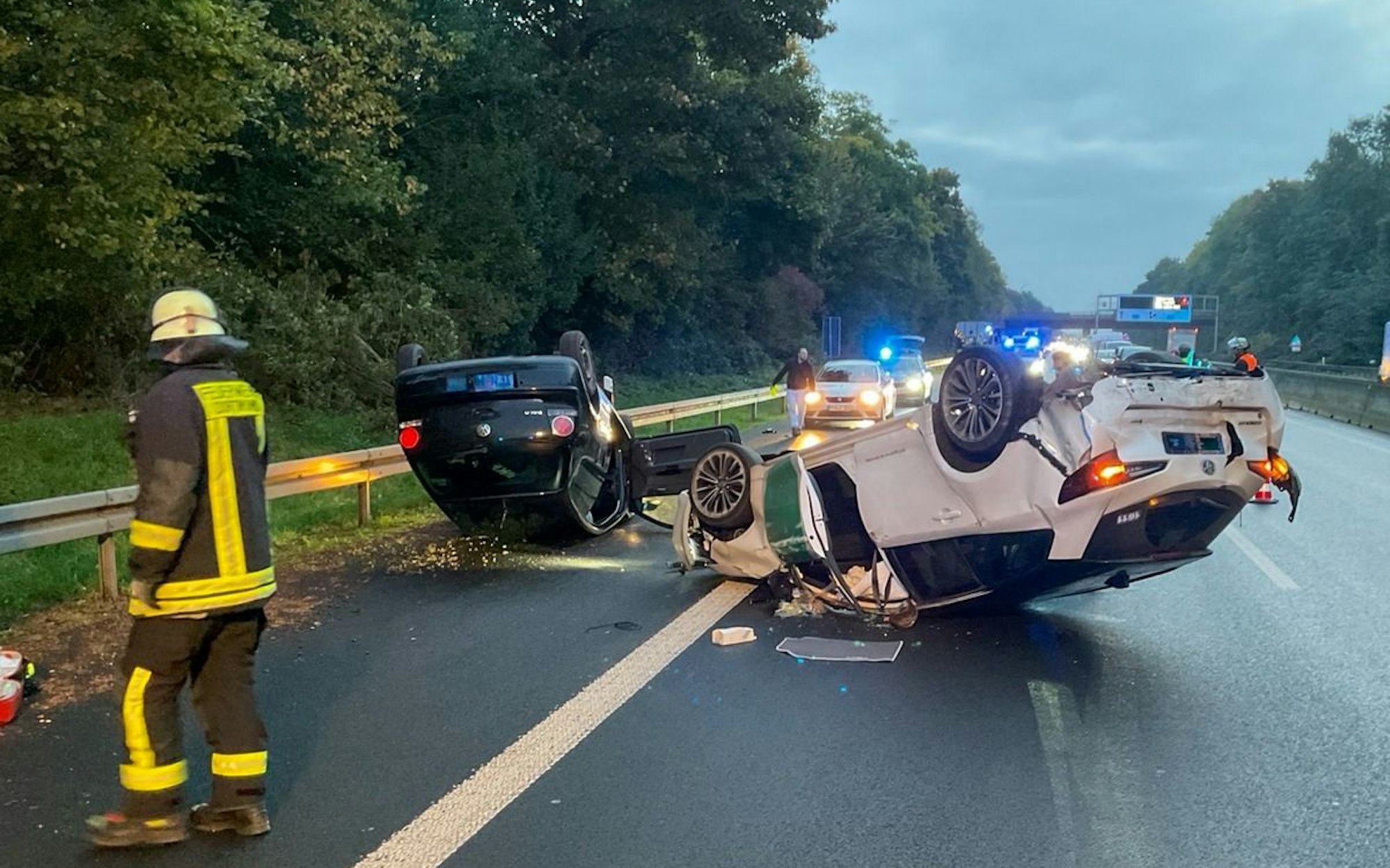 Zwei auf dem Dach liegende Unfallfahrzeuge auf der Autobahn A42.