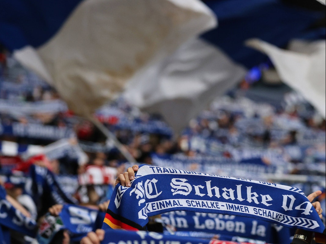 Schalke-Fans halten ihre Schals in die Höhe.