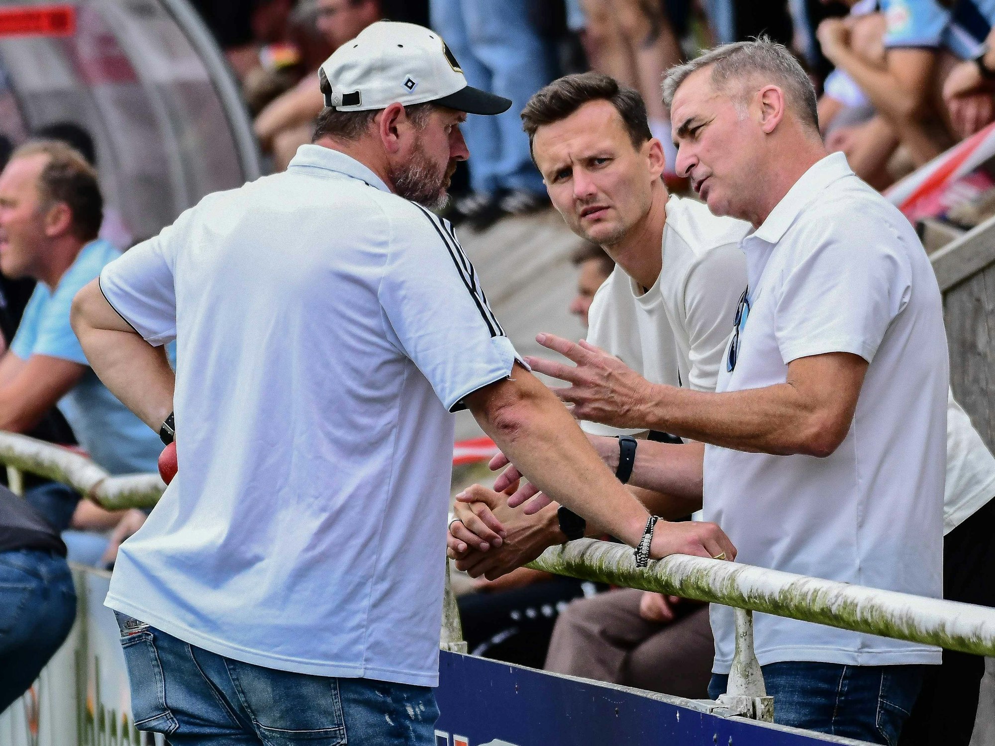 Steffen Baumgart, Claus Costa und Stefan Kuntz unterhalten sich an der Bande.