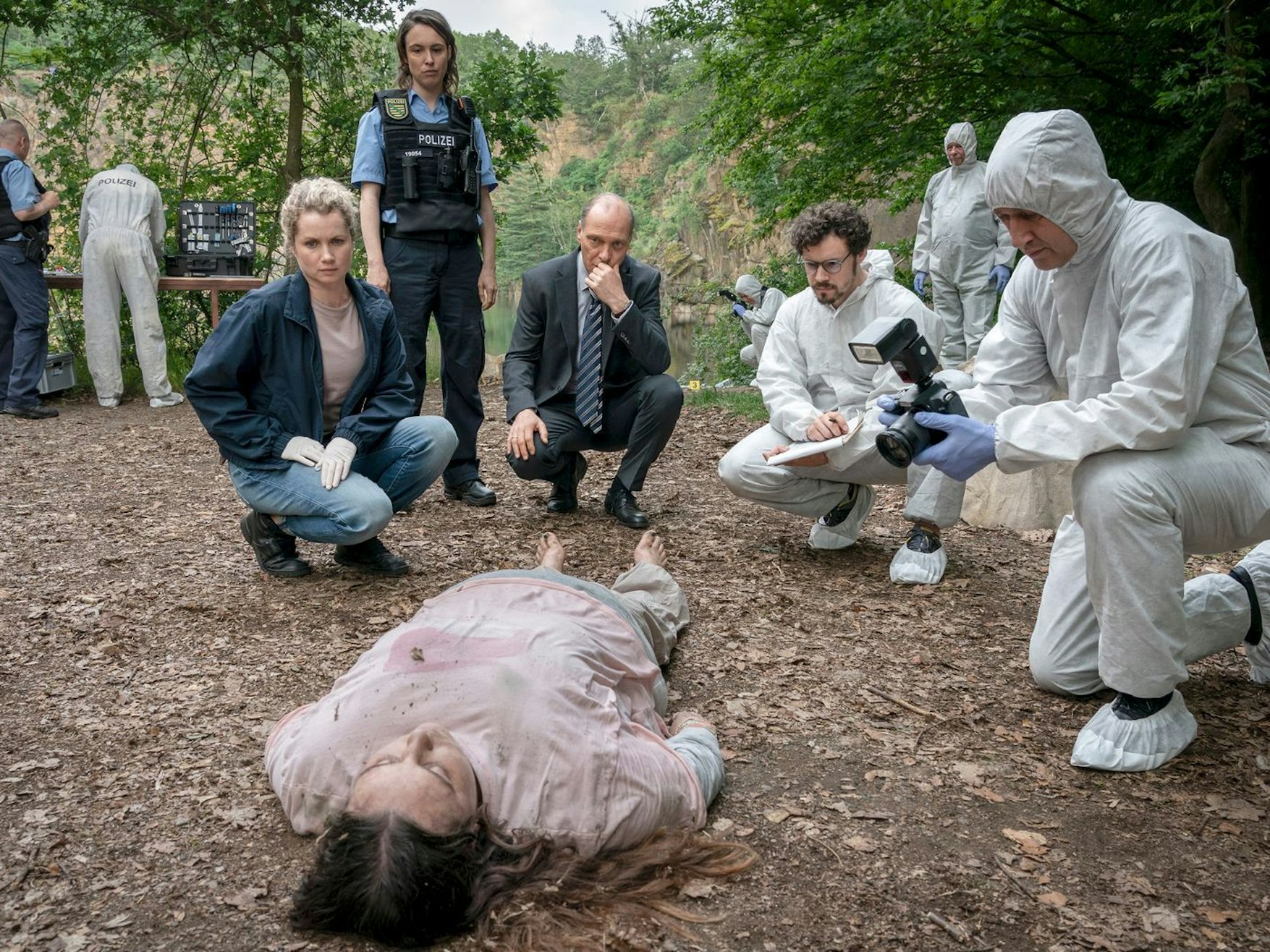 Eine 16-Jährige, die in einem Kinderheim lebte, wurde tot aus einem See geborgen. Leonie Winkler (Cornelia Gröschel, links), Polizistin Antje (Victoria Schulz), Peter Schnabel (Martin Brambach, dritter von links) und Dr. Himpe (Ron Helbig) inspizieren die Tote Lilly-Marie Reuter (Dilara Aylin Ziem). (Bild: MDR/MadeFor Film/Steffen Junghans)