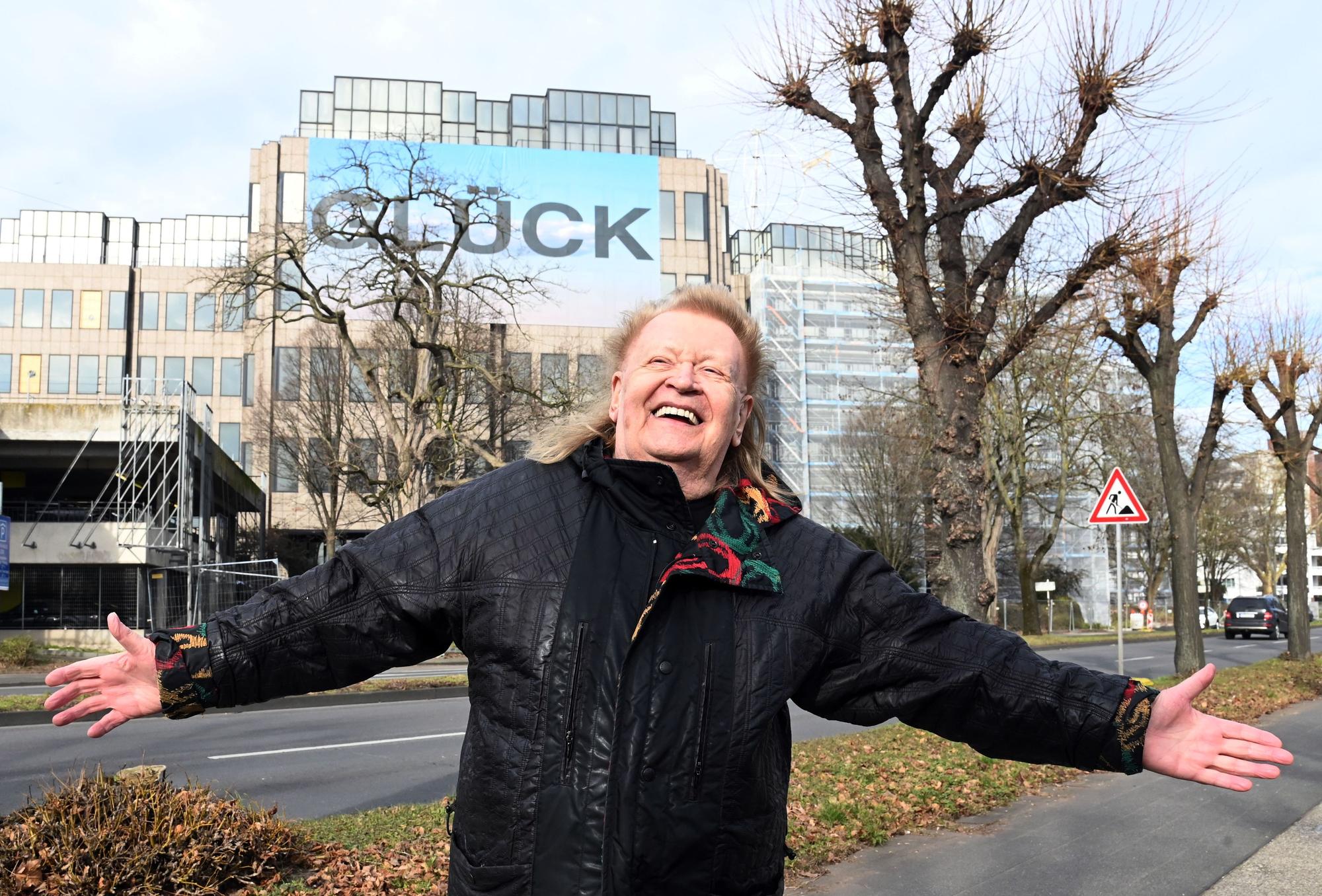 Künstler HA Schult vor seiner Installation „Glück“ an der DEVK-Zentrale.