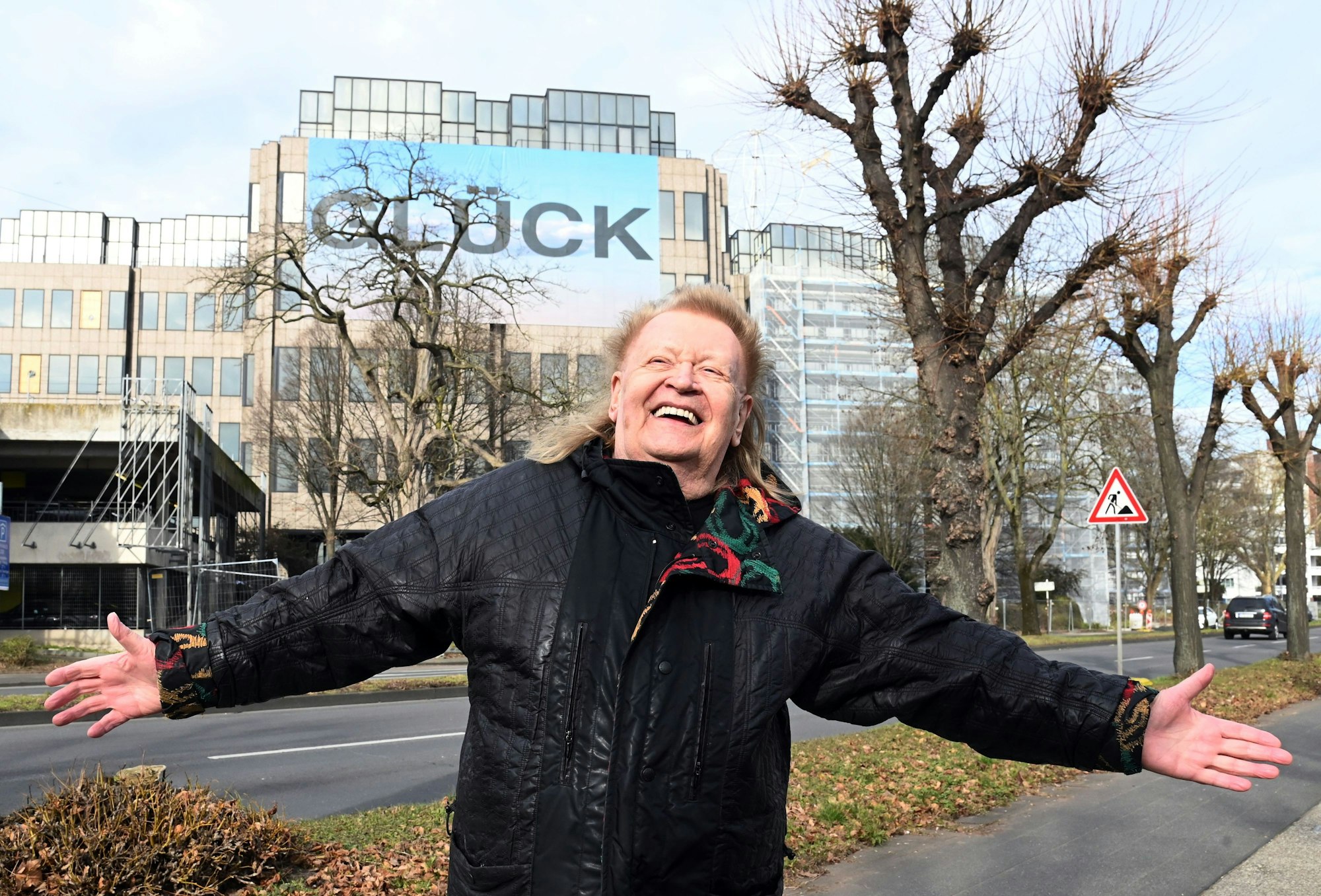 Künstler HA Schult vor seiner Installation „Glück“ an der DEVK-Zentrale.