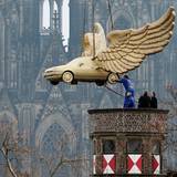 Das Flügelauto des Aktionskünstlers HA Schult hängt an einem Kran.
