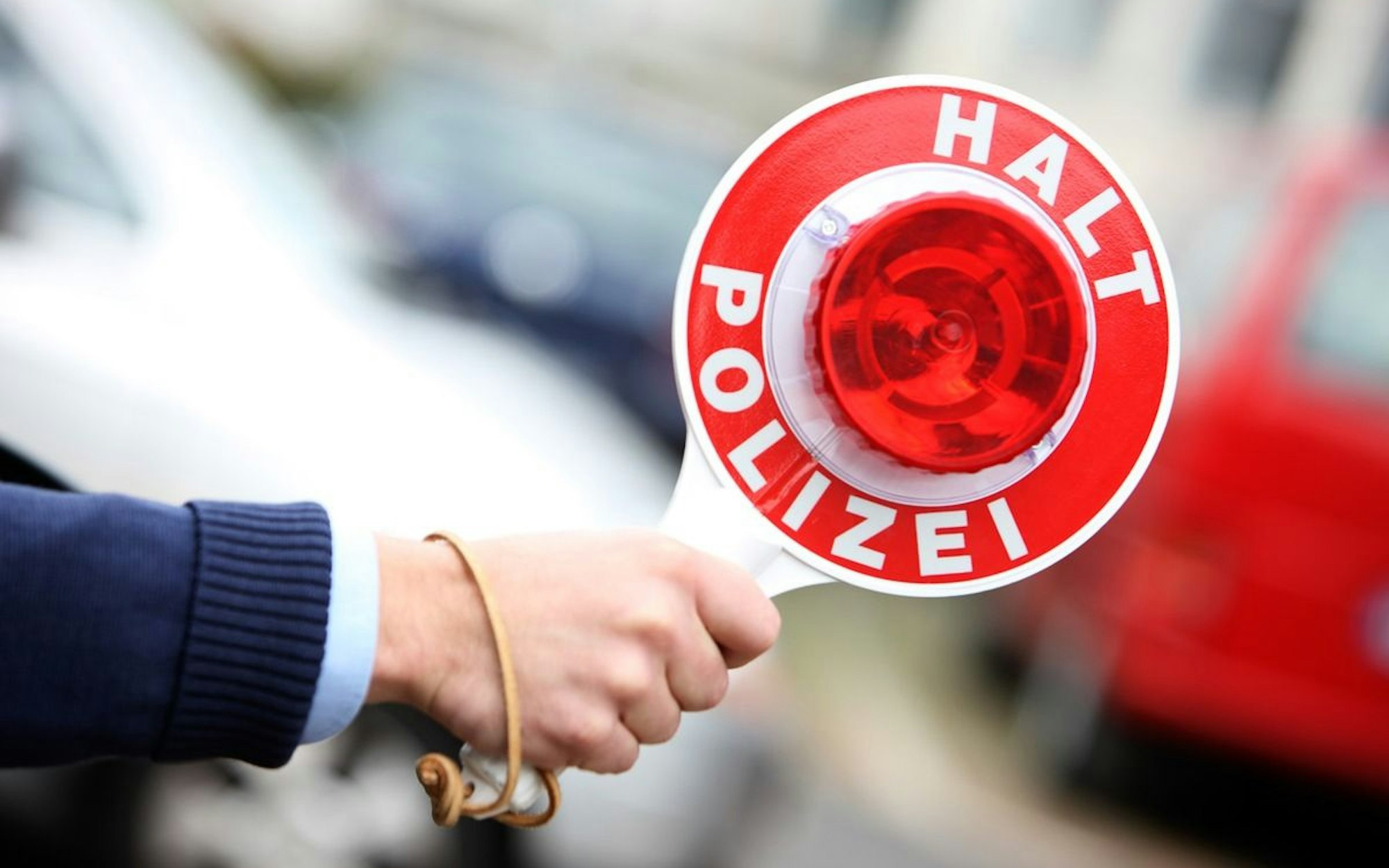 Eine Polizistin bei einer Verkehrskontrolle mit einer Anhaltekelle.