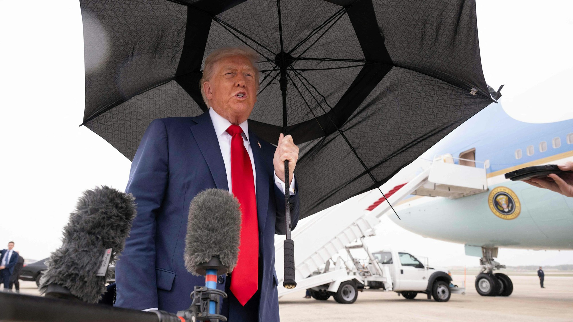 Donald Trump mit einem Regenschirm.