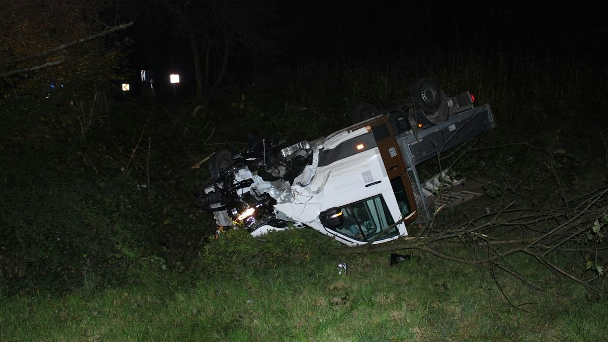 Ein Lkw liegt nach einem Unfall umgekippt an einer Böschung.