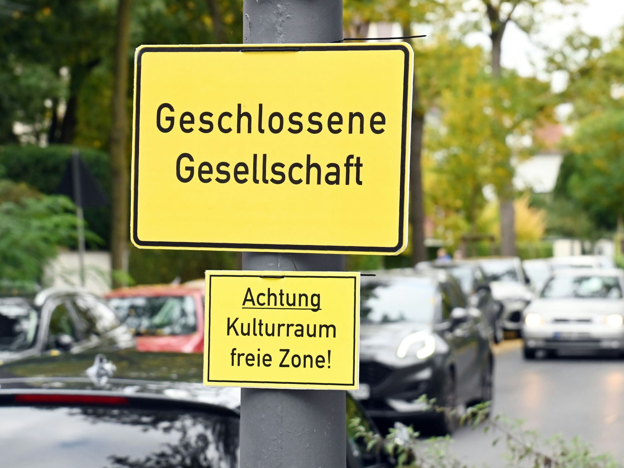 Auf einem Straßenschild steht „Geschlossene Gesellschaft“, auf einem kleineren darunter „Achtung Kulturraum freie Zone“.