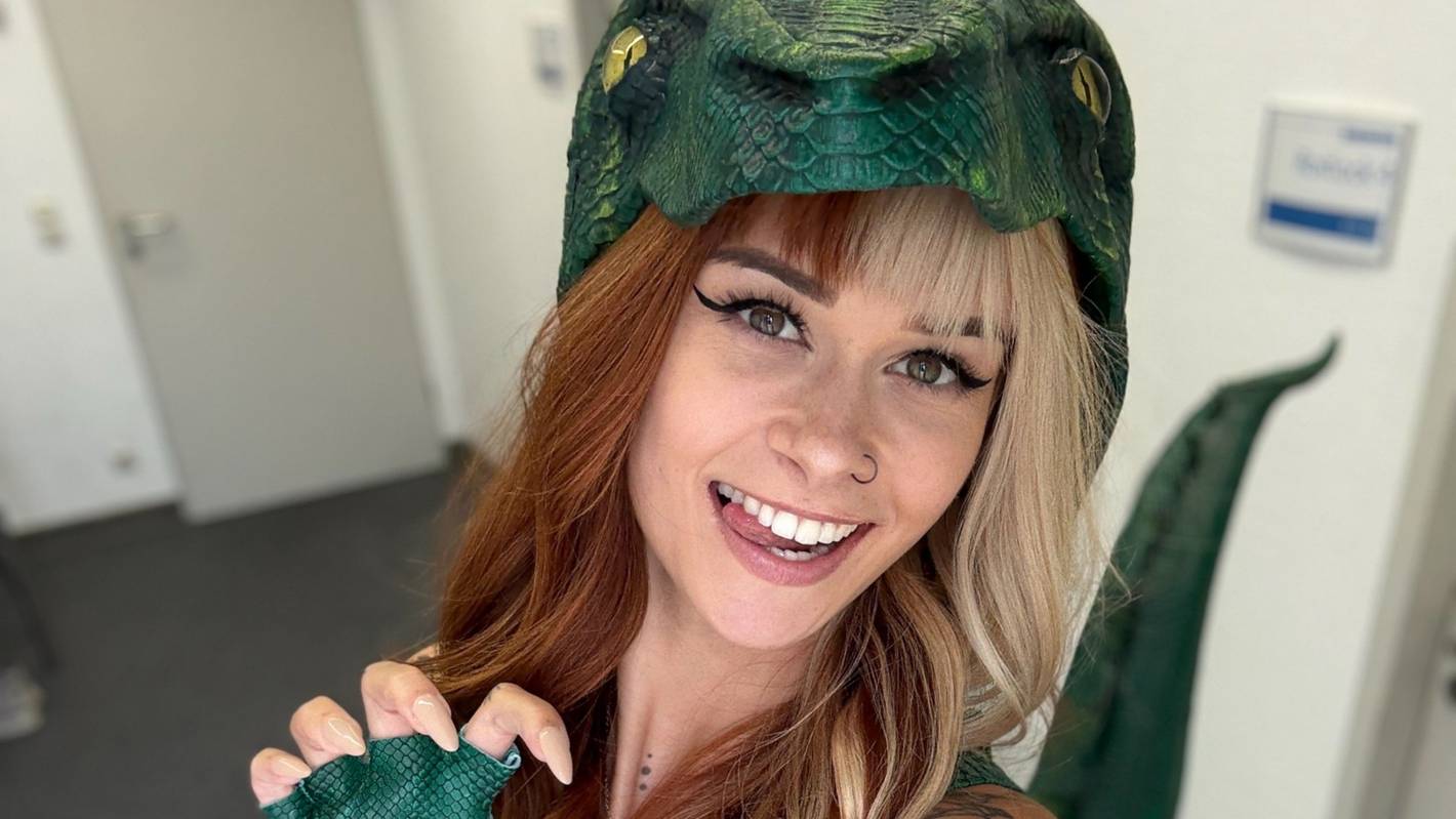 SallyDinosaur macht ein Selfie in einem Dinosaurierkostüm.