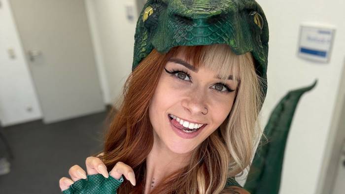 SallyDinosaur macht ein Selfie in einem Dinosaurierkostüm.