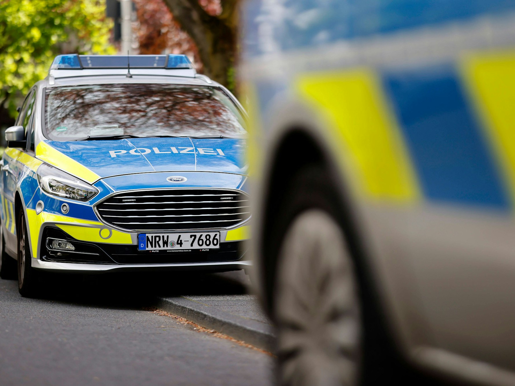 Polizeiautos begleiten eine Demo vor dem Bonner Arbeitsgericht.