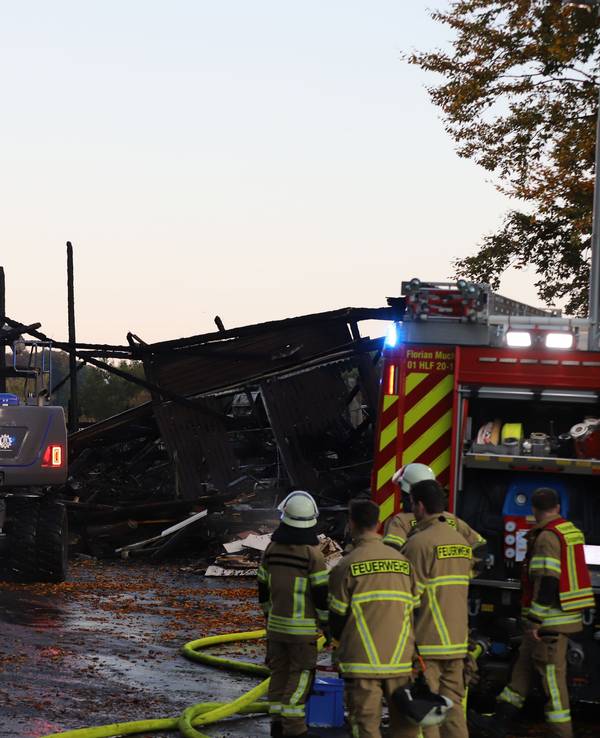 Einsatzkräfte von Feuerwehr und THW arbeiten an einer Lagerhalle mit Oldtimern, die in Brand geraten war. Die Feuerwehr brachte den Brand nach eigenen Angaben unter Kontrolle, war aber auch am frühen Morgen noch am Einsatzort.