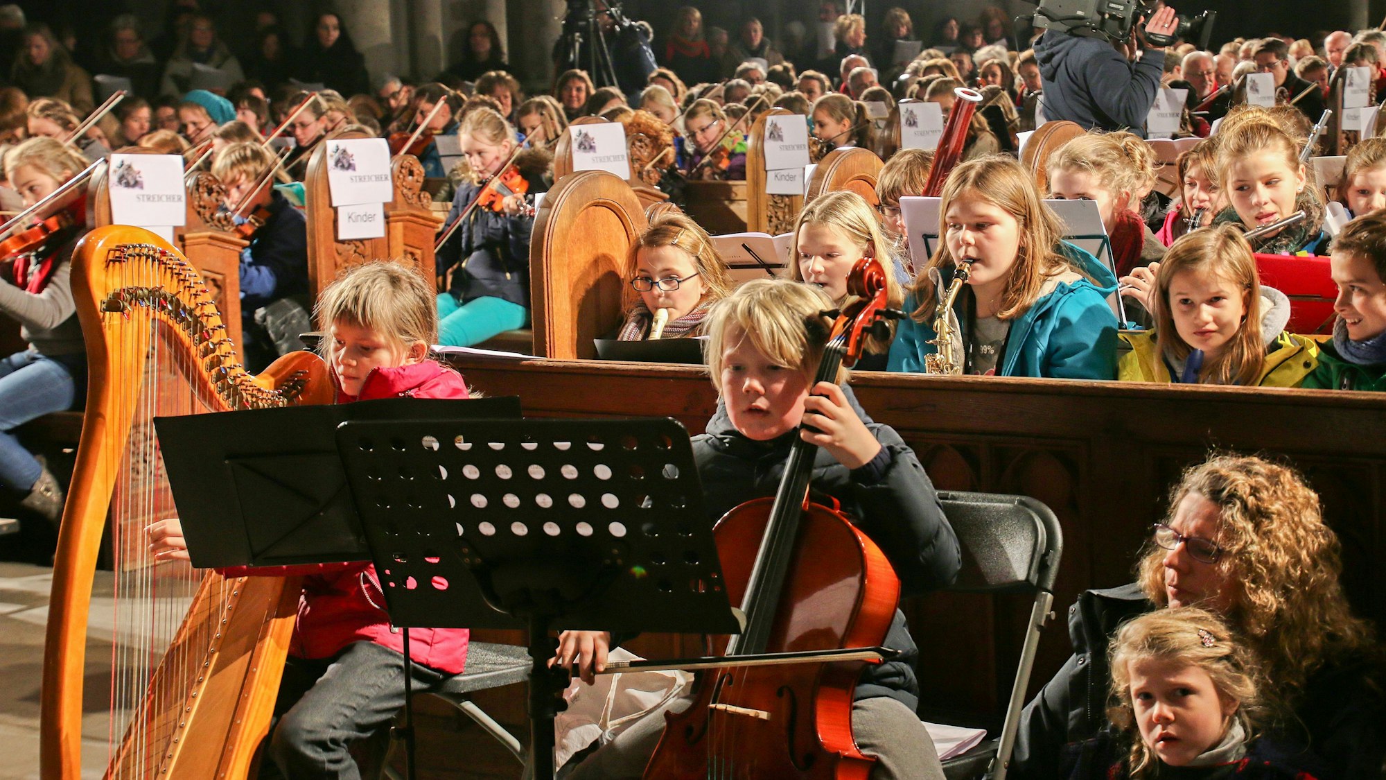 Menschen spielen im Kölner Dom ihre Instrumente.