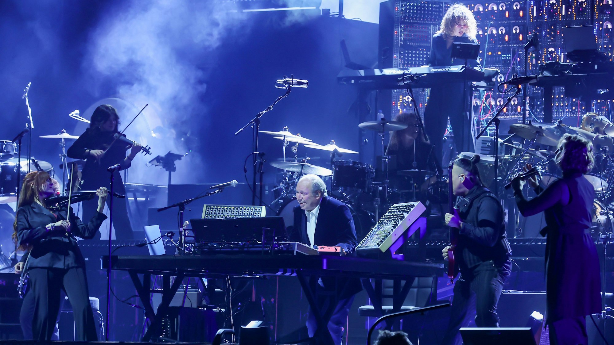Hans Zimmer steht mit vielen anderen Musikern auf der Bühne der Lanxess-Arena.