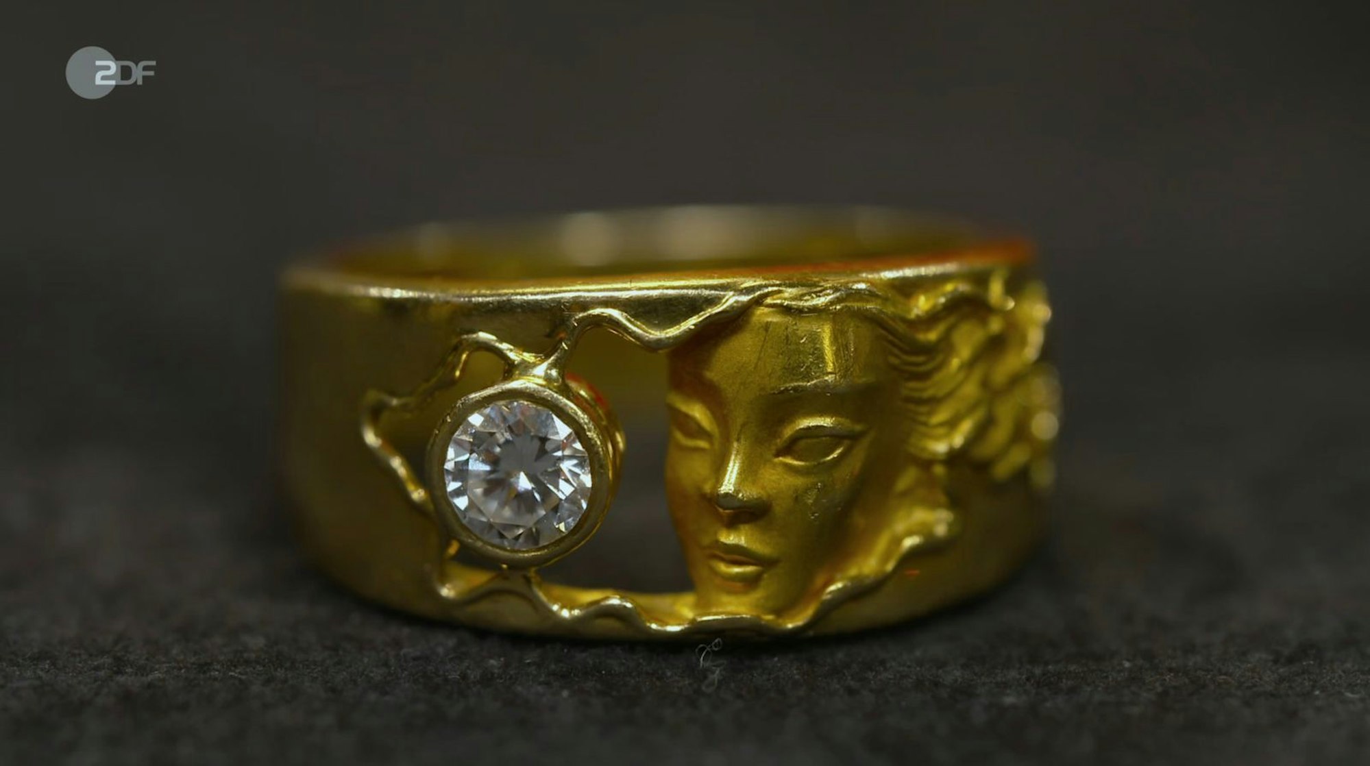 Als weiteres Objekt der Sendung wurde ein Ring mit Frauengesicht der spanischen Schmuckmanufaktur Carrera y Carrera von Wendela Horz in den 1980er/90er Jahren datiert. Für den Schmuck aus 750er Gold mit Brillant (0,4 Karat) wünschte sich der Verkäufer 1.600 Euro, Horz schätzte 1.200 bis 1.300 Euro und David Suppes zahlte 1.700 Euro. (Bild: ZDF)