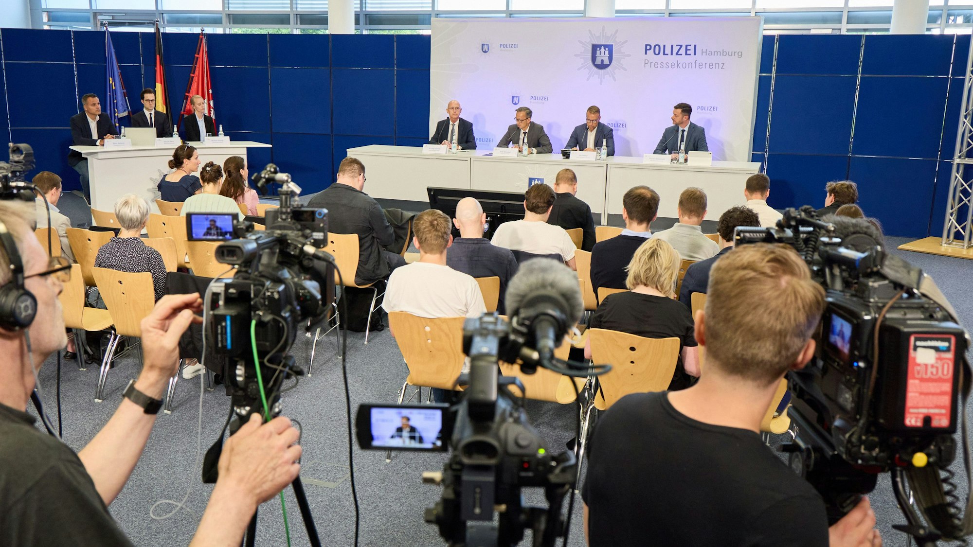 Pressekonferenz mit zahlreichen Journalisten, Journalistinnen und Fernseh-Teams.