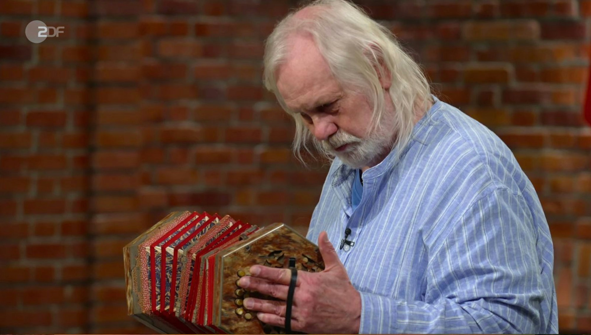 Steve Mandel - Antiquitätenhändler und Musiker - entlockte der Konzertina erstaunlich passable Töne. Für sein spontanes Konzert auf dem alten Instrument gab es sogar Applaus von seinen Kollegen: „Bravo“, rief Elke Velten ganz begeistert, auch Benjamin Leo zeigte sich beeindruckt von dem „Wahnsinn“ und Julian Schmitz-Avila lachte: „Ich liebe dich!“ (Bild: ZDF)