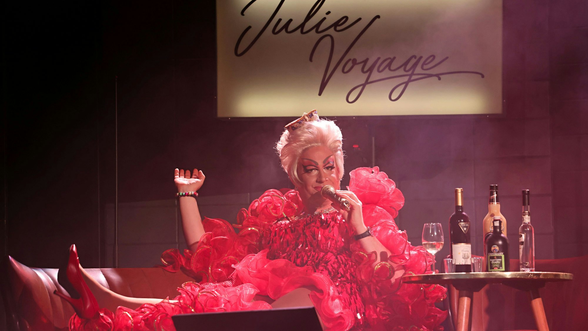 Ken Reise liegt als Julie Voyage auf einem Sofa.