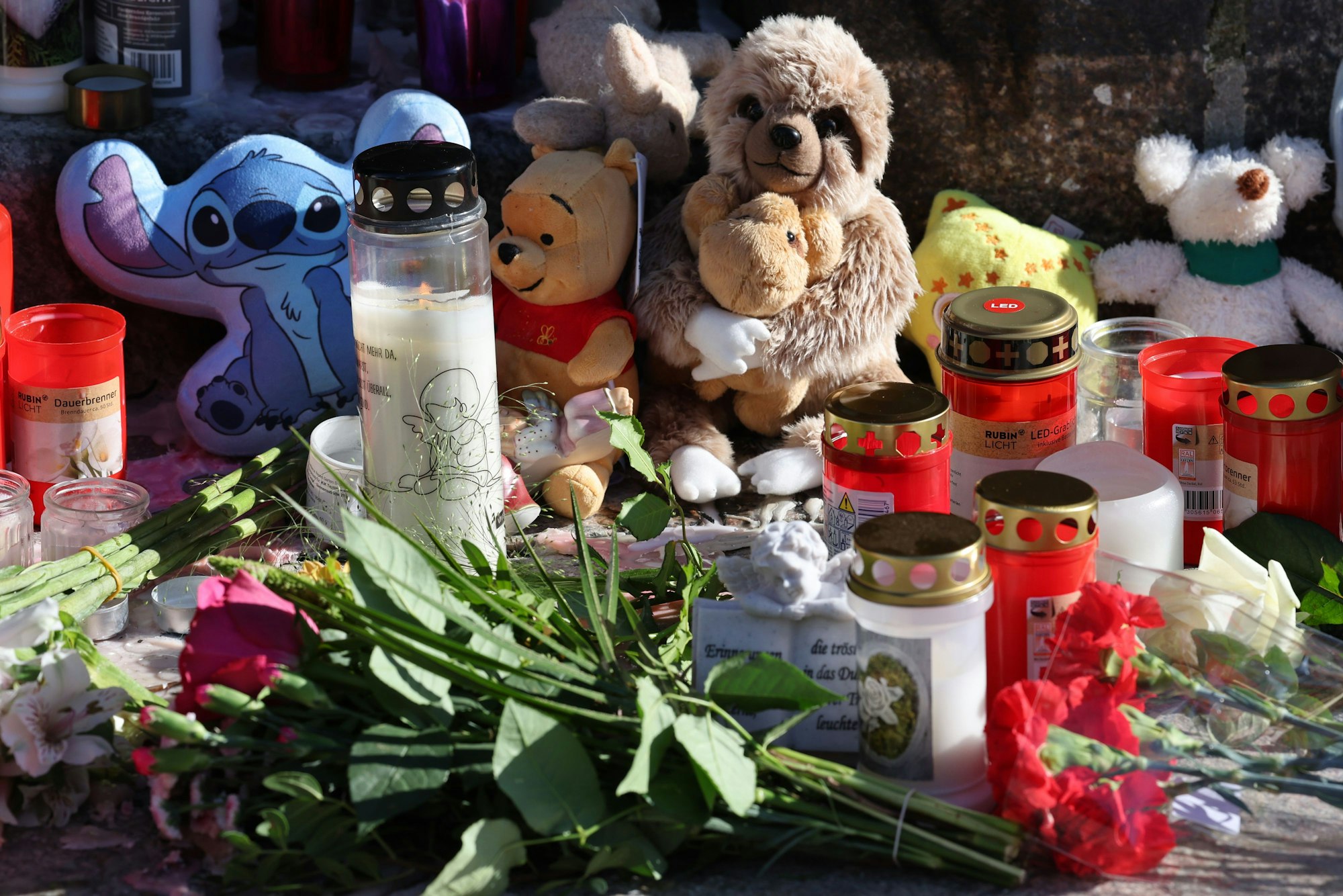 Vor der Marienkirche stehen Grablichter, Blumen und Plüschtiere im Gedenken an den vermissten achtjährigen Fabian.