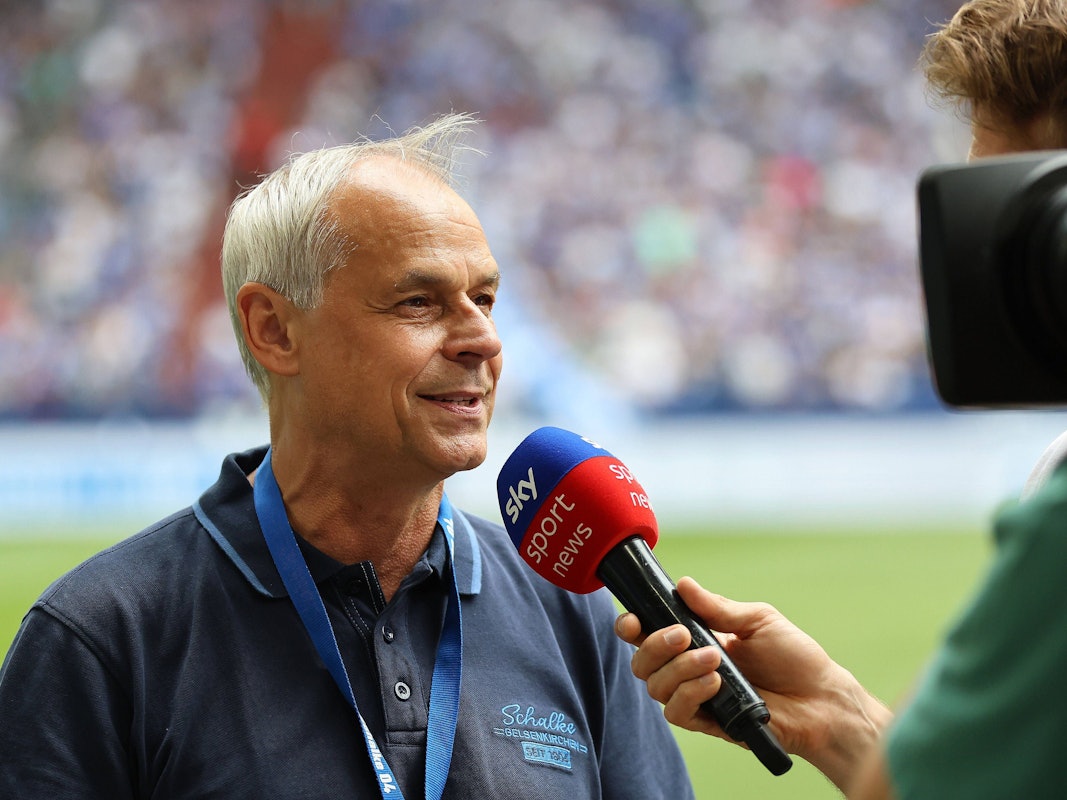 Olaf Thon spricht bei einem Spiel in ein Sky-Mikro.
