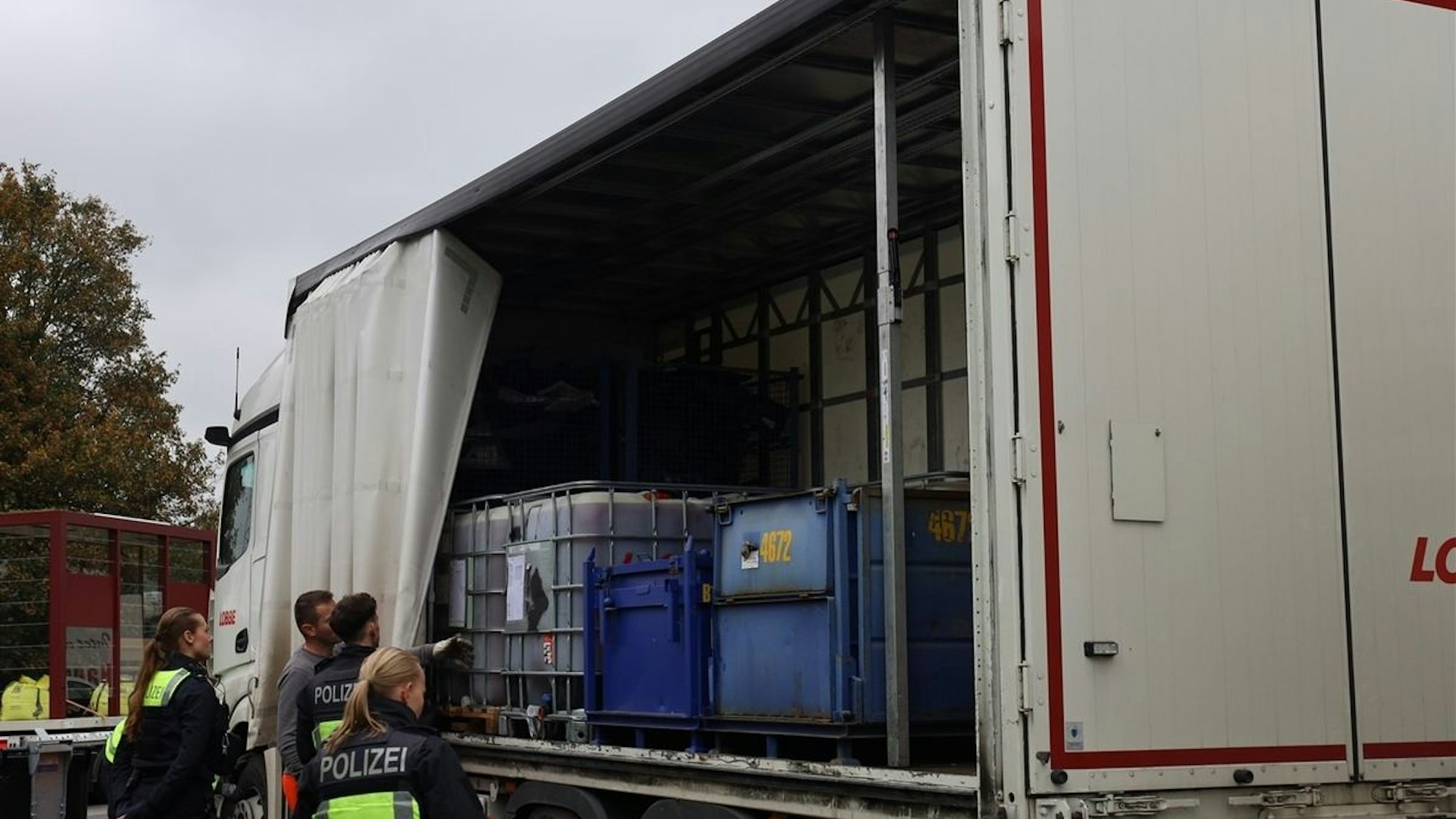 Polizisten bei einer Lkw-Kontrolle auf einem Rastplatz.