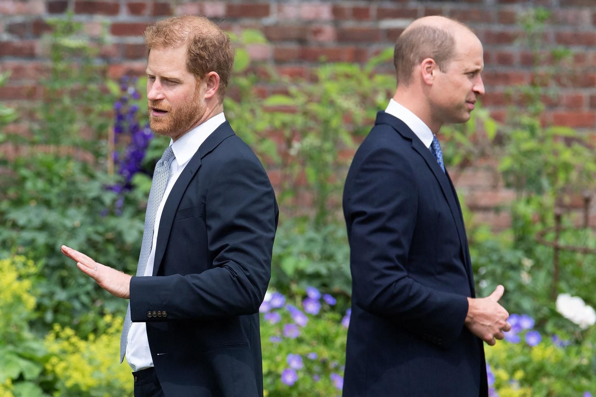 Prinz Harry und Prinz William stehen mit dem Rücken zueinander.