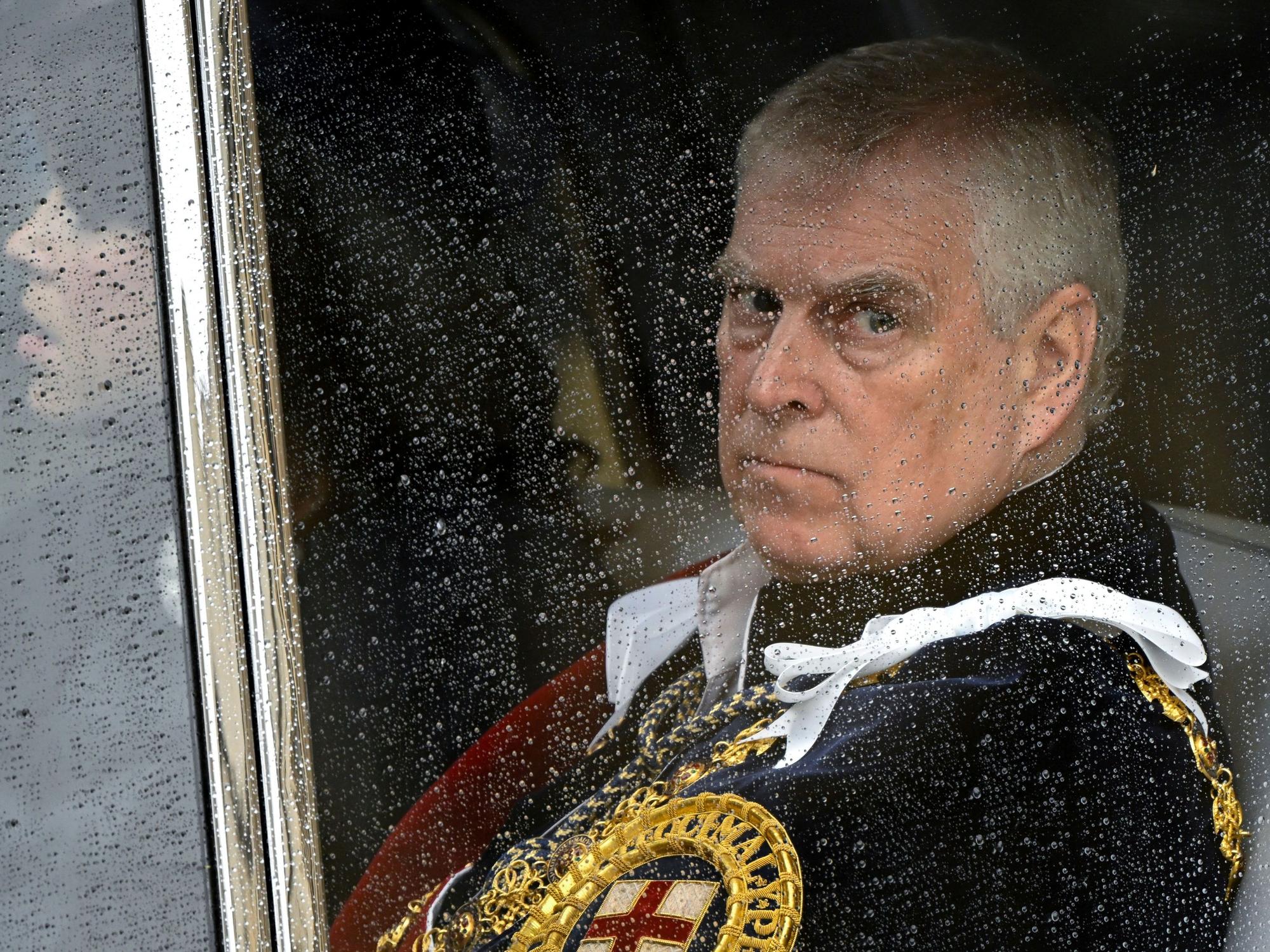 Prinz Andrew guckt durch ein regennasses Fenster.
